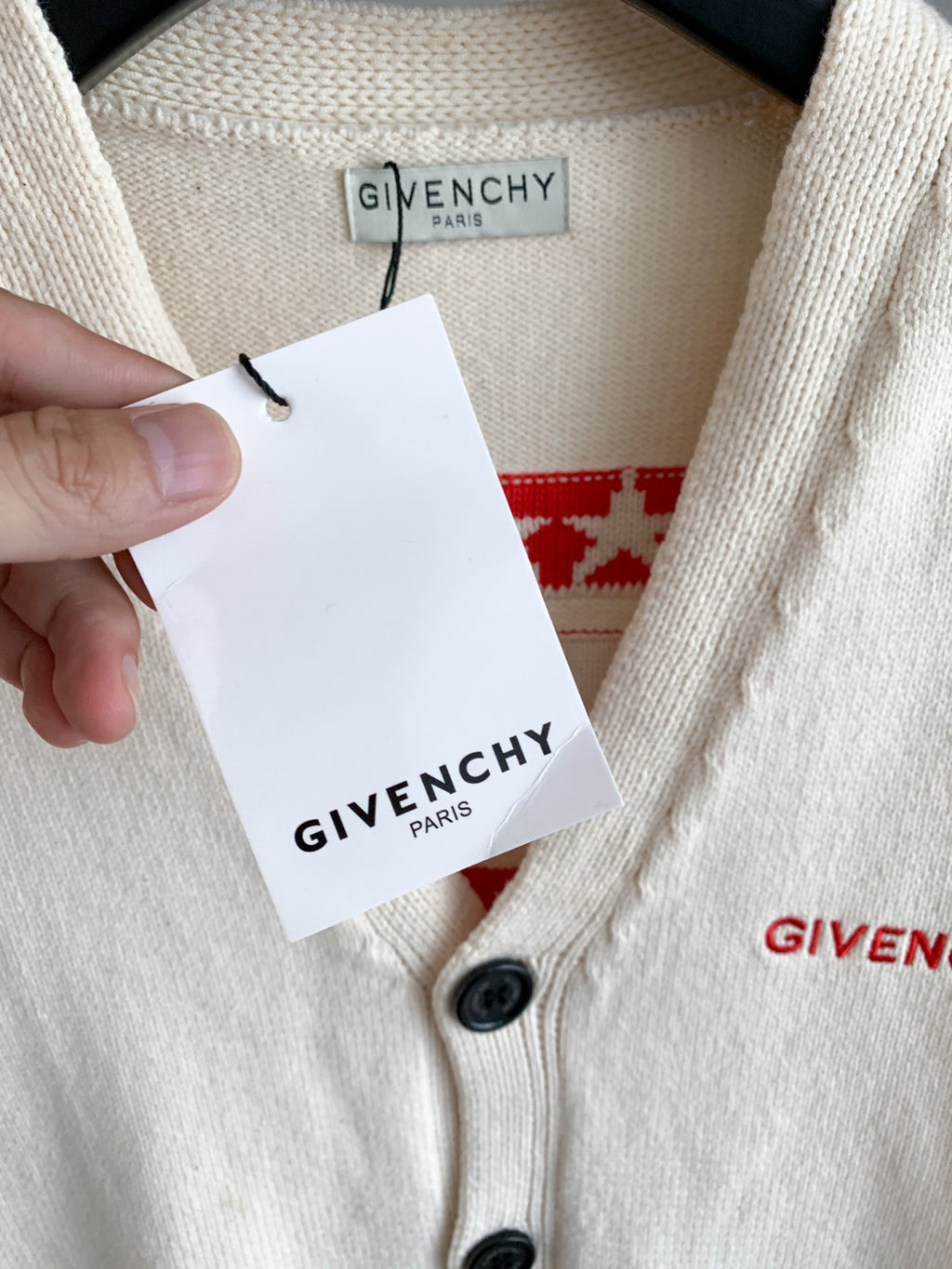 White knit cardigan collar with black buttons and attached GIVENCHY clothing tag