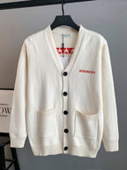 White knit cardigan with V-neck, black button front and two patch pockets