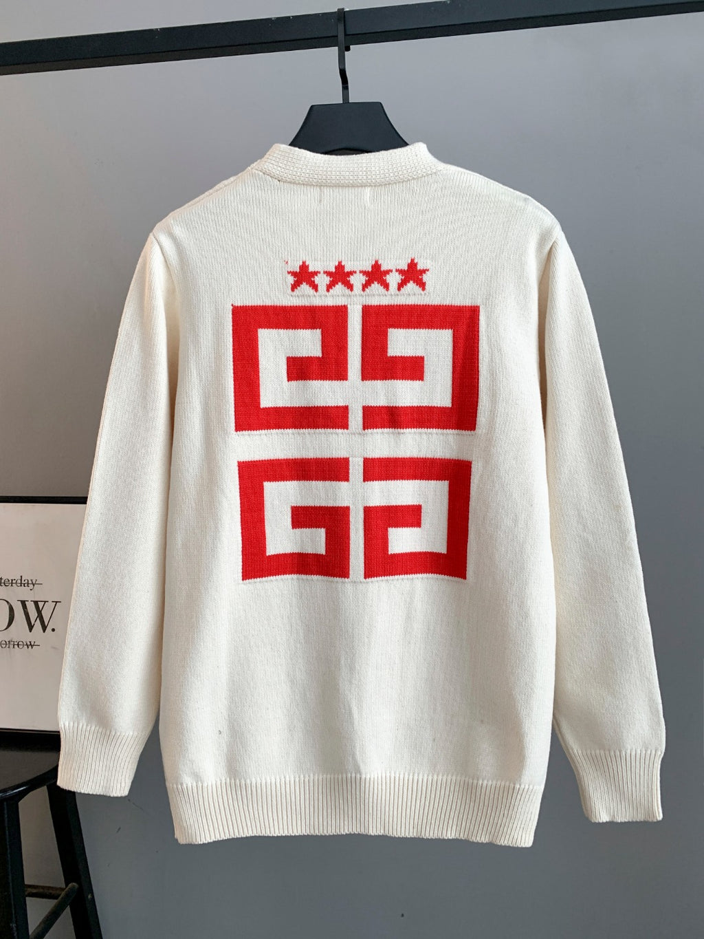 White knit cardigan back with large red geometric crest graphic