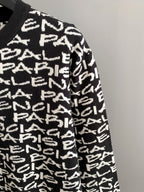 Side view of black long-sleeve sweater with white repeating logo text pattern