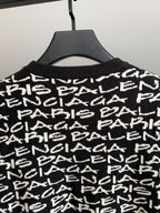 Close-up of black sweater upper body with white repeating logo text