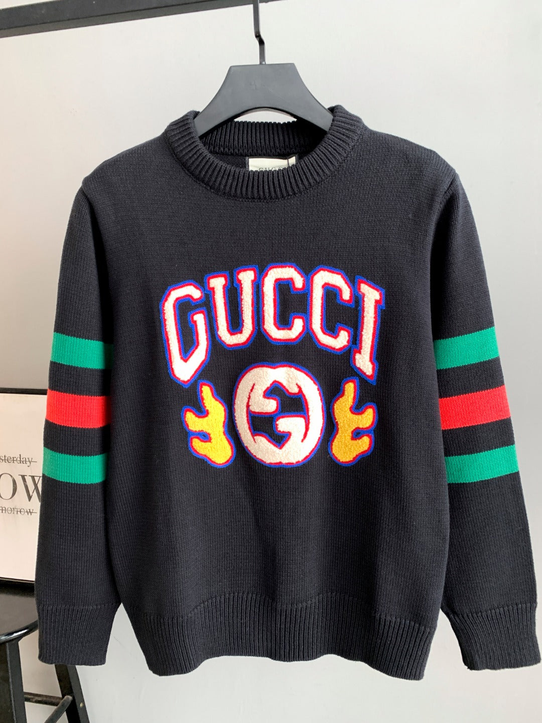 Gucci knit sweater in dark gray with large colorful “GUCCI” logo on front