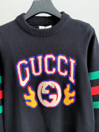 Gucci knit sweater front view in dark gray with colorful “GUCCI” logo