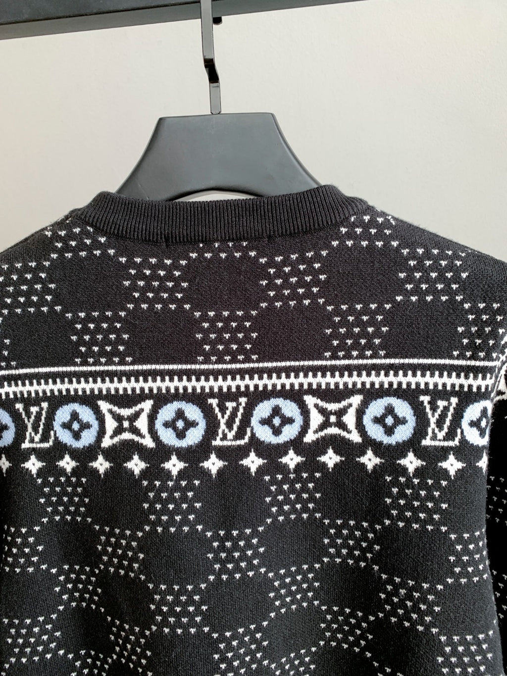 Upper front view crew-neck knit sweater with white geometric monogram pattern