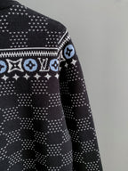 Shoulder and sleeve view of dark knit sweater with white monogram band