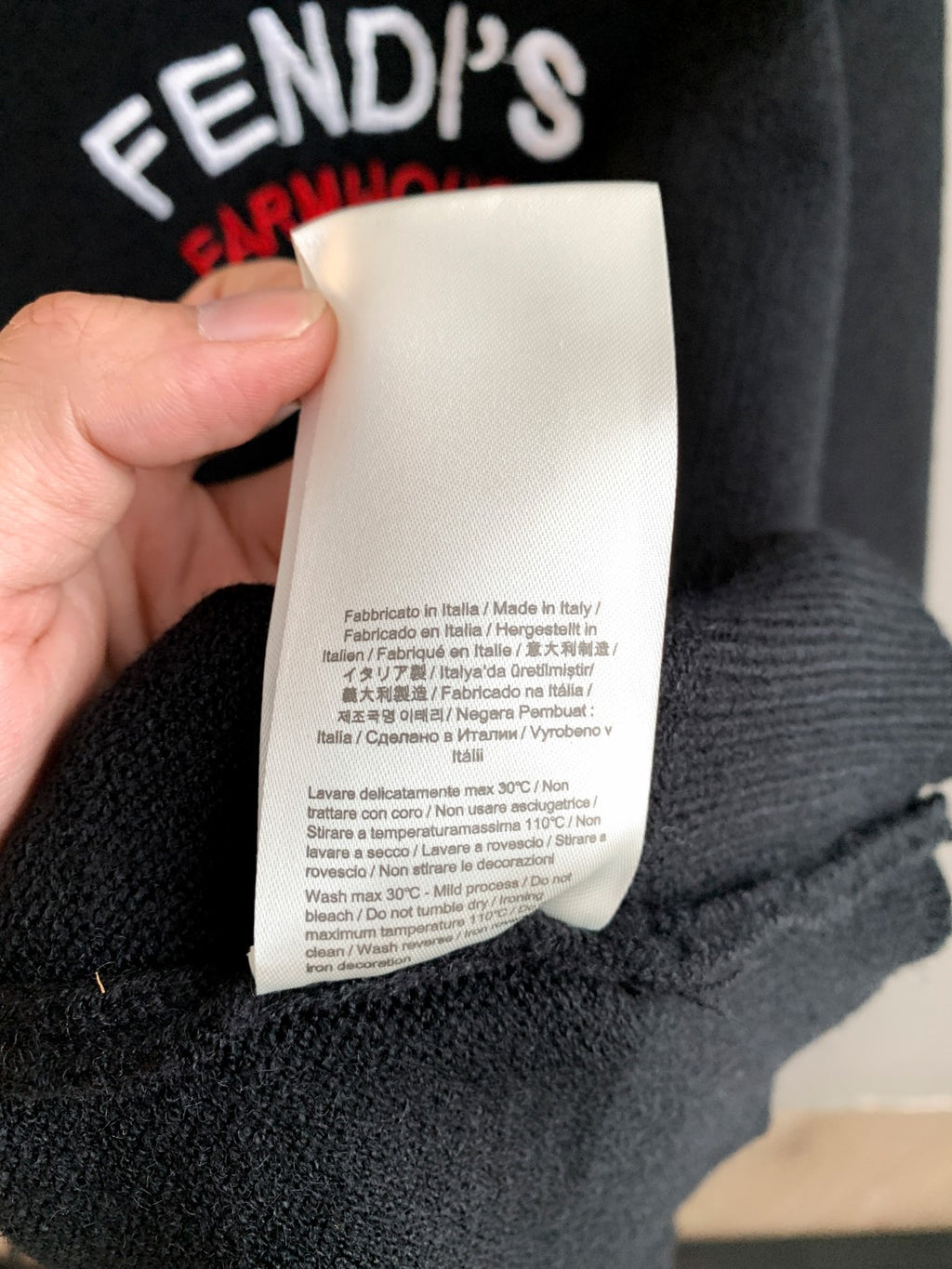 Black Fendi sweater care label attached near ribbed collar