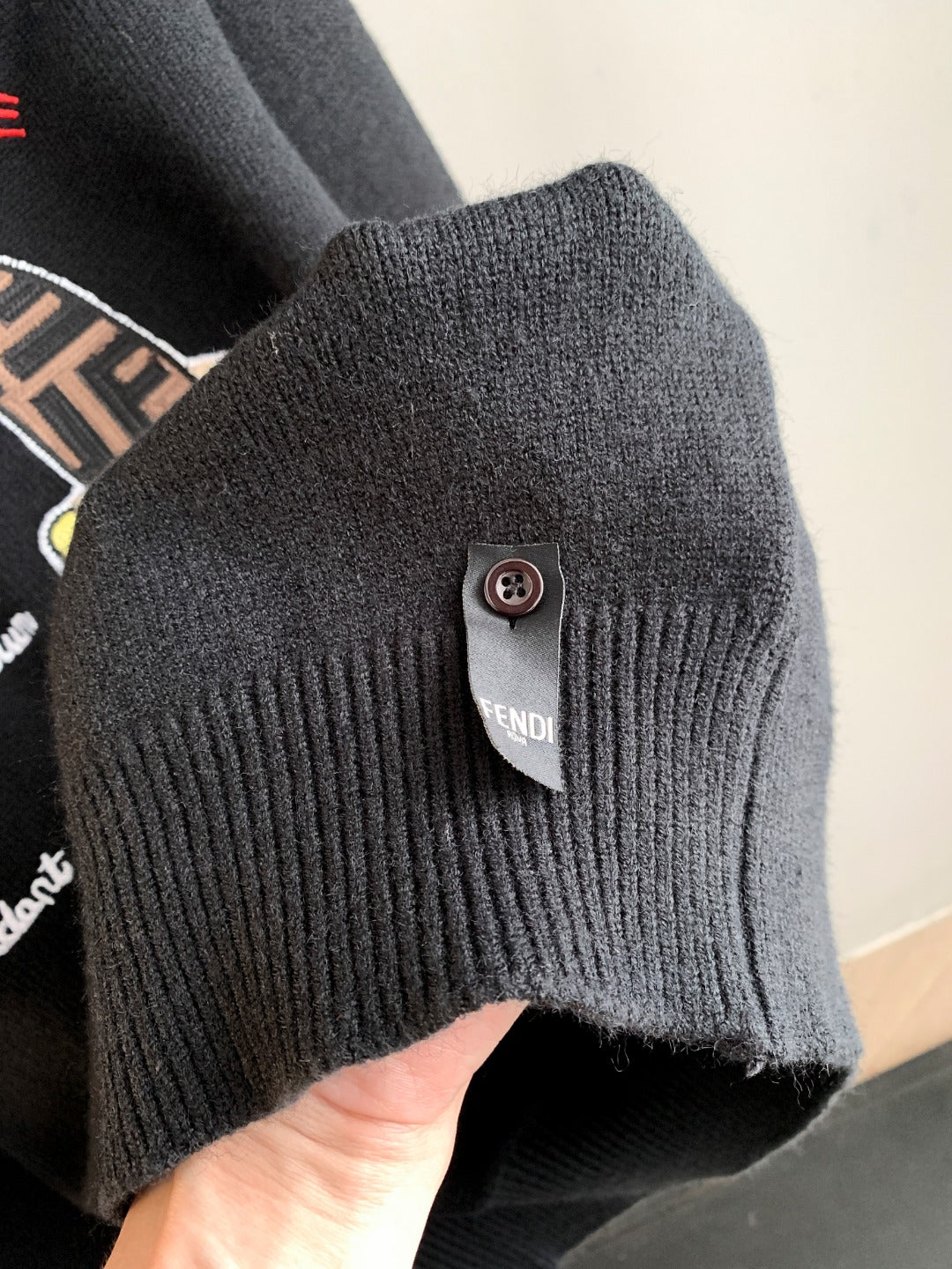 Black Fendi sweater ribbed cuff with round button and brand patch