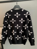 Black knit sweater with white monogram-style pattern, crew neck, long sleeves