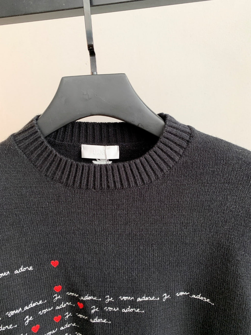 Dark charcoal sweater with ribbed crewneck and embroidered-style red heart script detail
