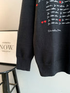 Dark charcoal knit sweater with partial red heart and script graphic, ribbed hem