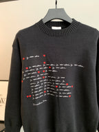 Dark charcoal knit crewneck sweater with centered red heart and script graphic