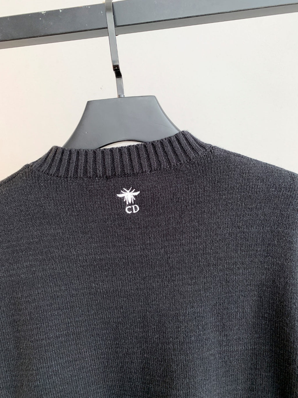 Dark charcoal knit sweater with small Dior logo on upper back near collar