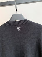 Dark charcoal knit sweater with small Dior logo on upper back near collar