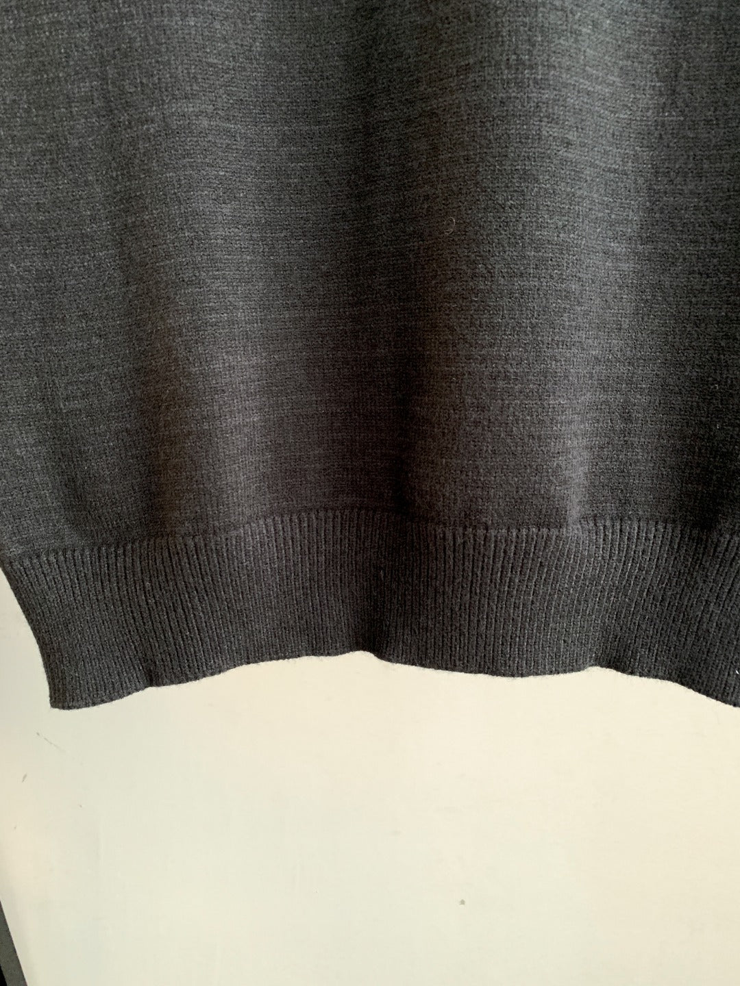 Dark charcoal knit sweater hem with ribbed bottom band