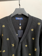 Dark knit cardigan neckline with button placket and gold monogram motifs