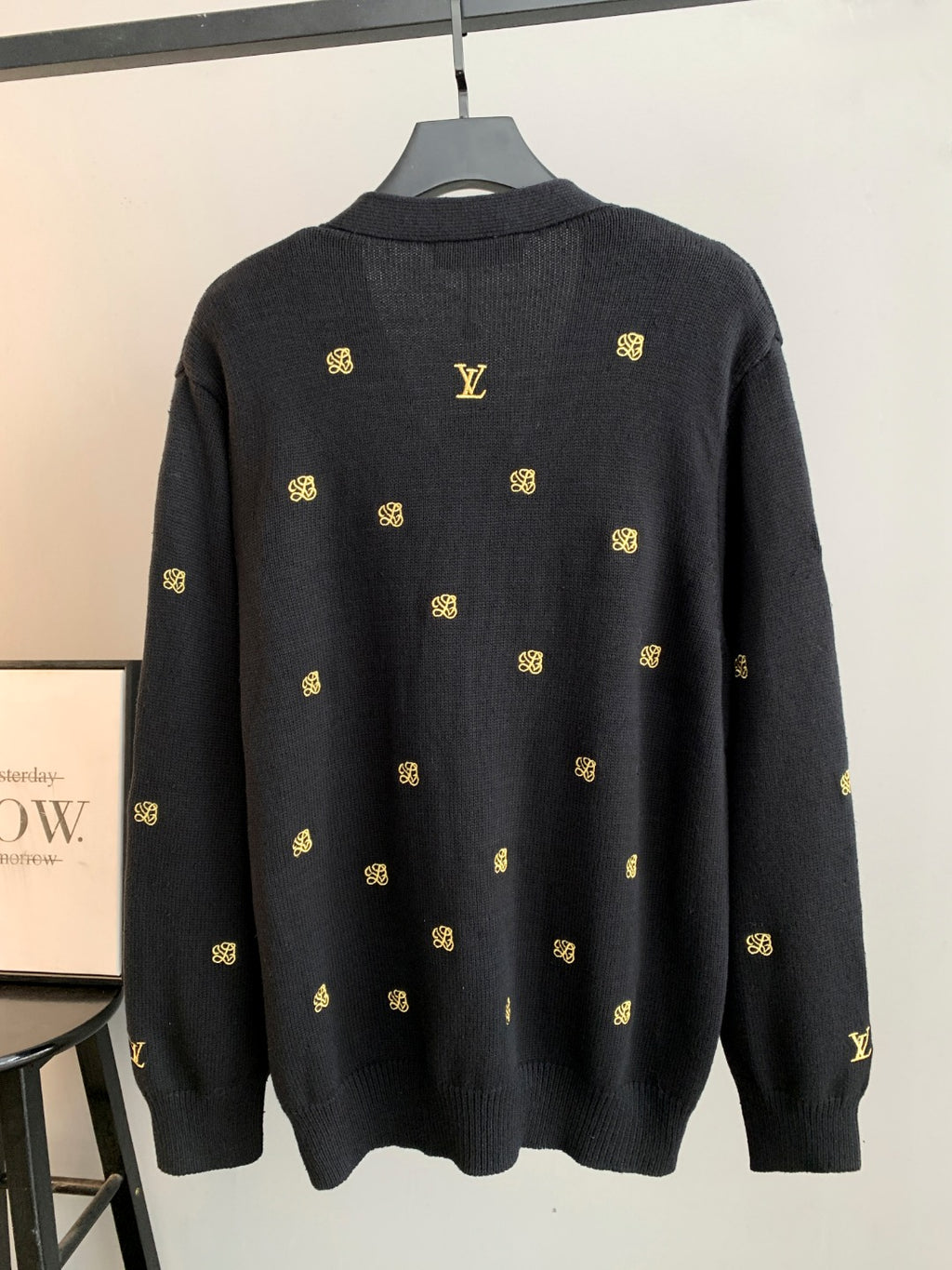 Dark knit cardigan, back view with gold monogram pattern and ribbed collar