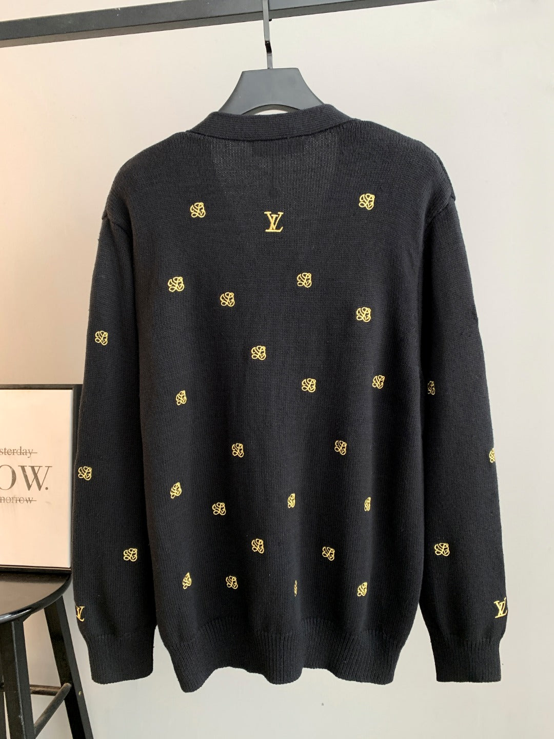 Dark knit cardigan, back view with gold monogram pattern and ribbed collar