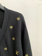 Dark knit cardigan sleeve with small gold monogram accents