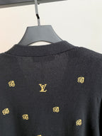Dark knit cardigan back with gold monogram V-shaped motif and ribbed collar
