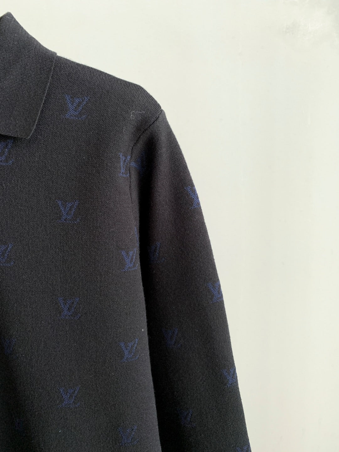 Long-sleeve polo sleeve with blue monogram detail on dark gray knit