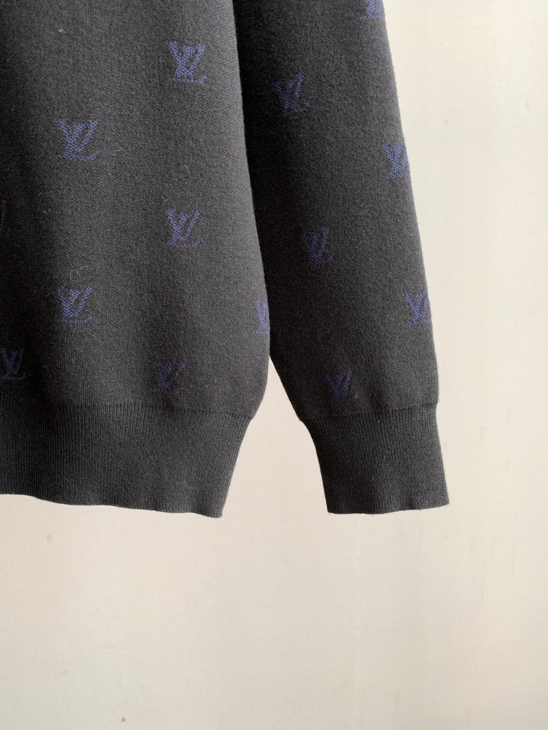 Long-sleeve polo hem and cuffs with blue monogram pattern on dark gray knit