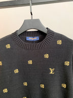 Long-sleeve knit sweater with ribbed crew neck and gold monogram pattern.