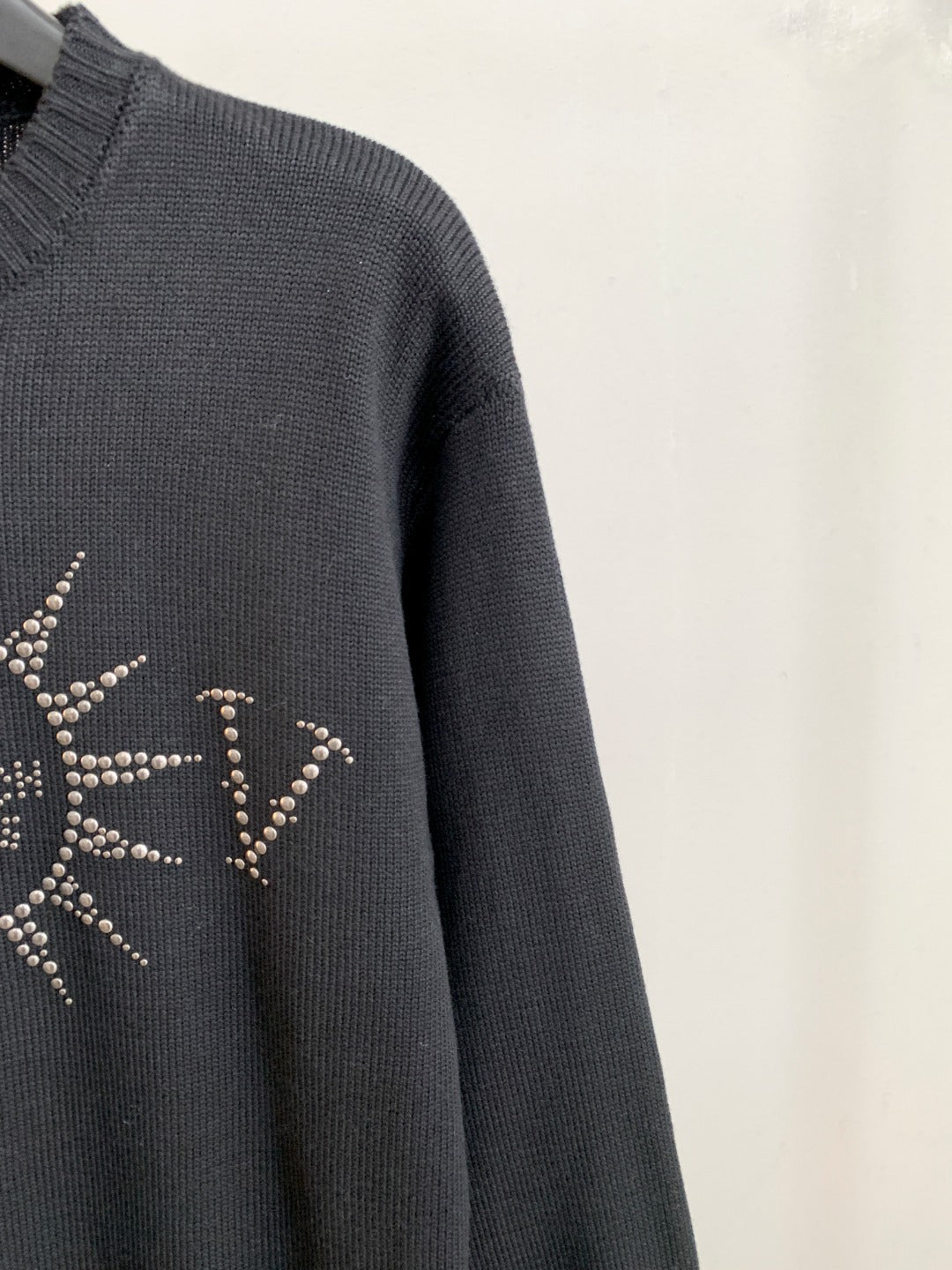 Dark knit sweater sleeve with partial rhinestone design on the side