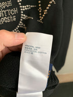 Dark knit sweater fabric tag reading 100% cotton