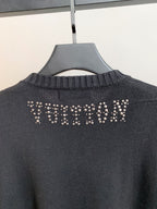 Dark knit sweater back with rhinestone logo across the upper back