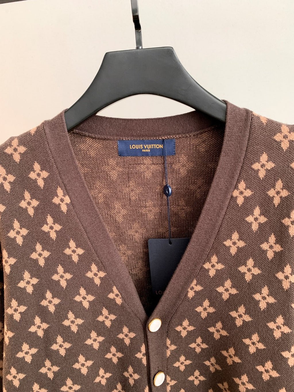 Brown monogram cardigan close-up at V-neck and button placket
