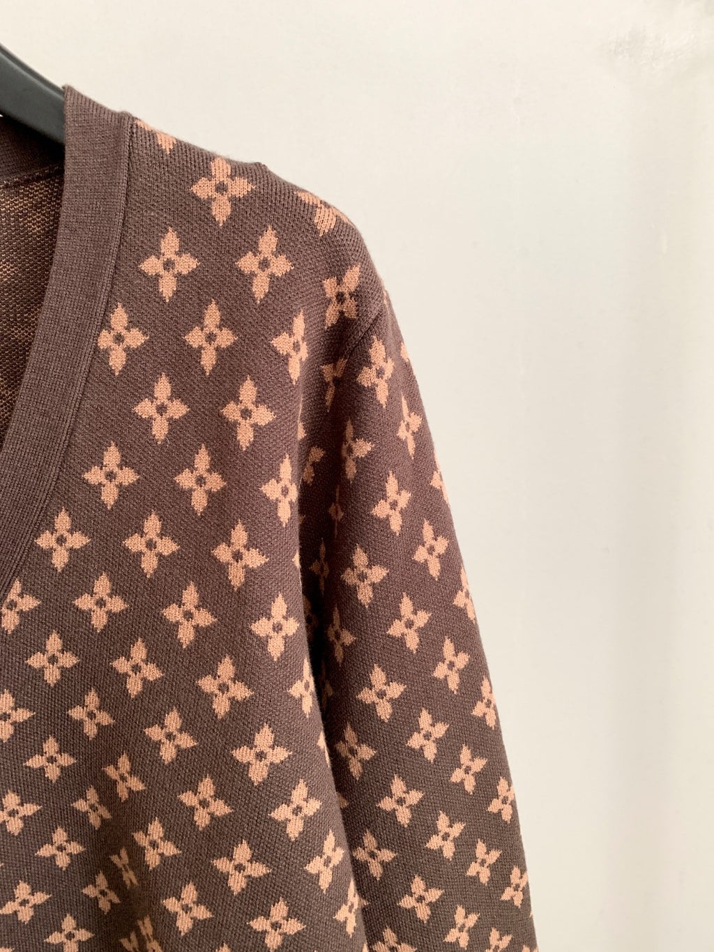 Brown monogram cardigan sleeve with repeating flower motif pattern