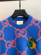 Blue knit sweater neckline with red GG logo shapes and a small green dragon graphic