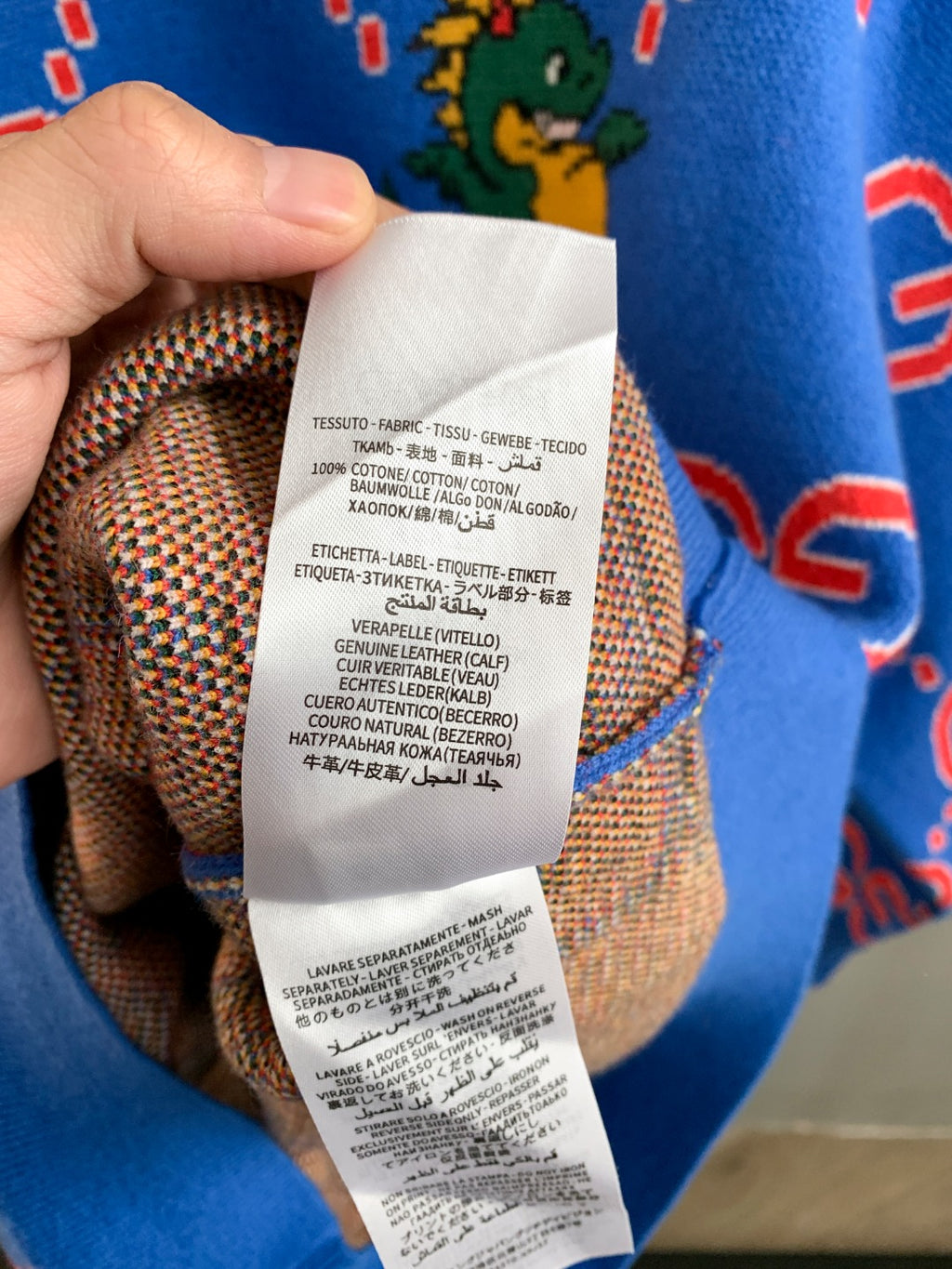 Blue knit sweater with inner fabric and care label visible