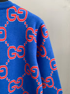 Blue knit sweater side with red GG logo motifs and dotted outlines