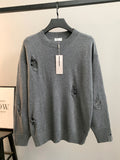 Gray knit sweater with ribbed crew neck and small embroidered motifs on chest