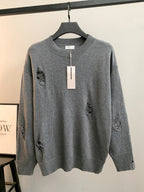 Gray knit sweater with ribbed crew neck and small embroidered motifs on chest