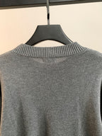 Back view of gray knit sweater with ribbed crew neck and no visible graphics