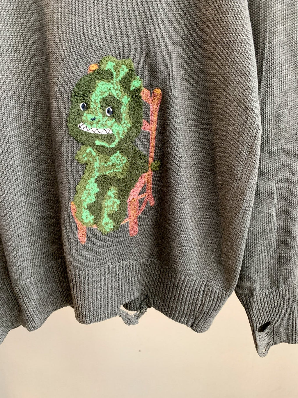 Gray knit sweater with colorful character graphic on back and ribbed cuffs