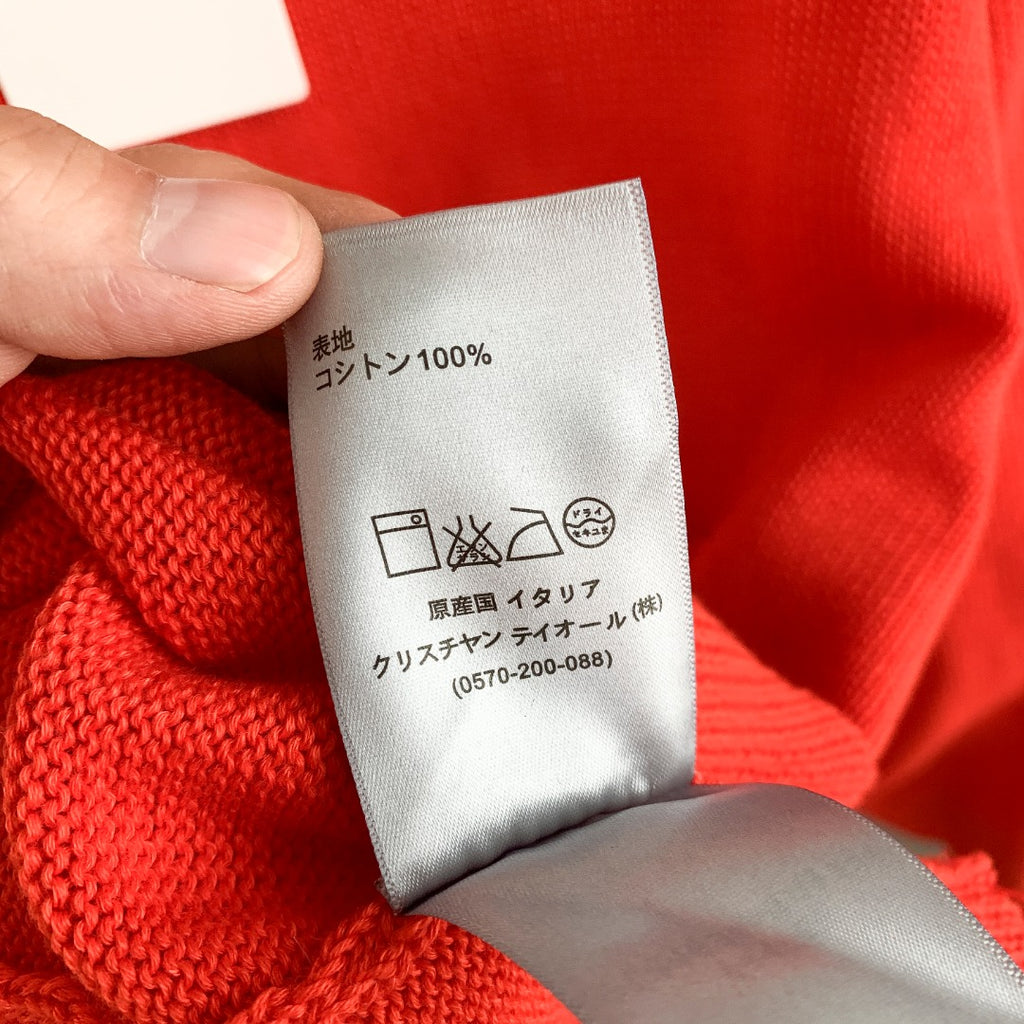 Dior red knit sweater care label showing 100% content and washing symbols