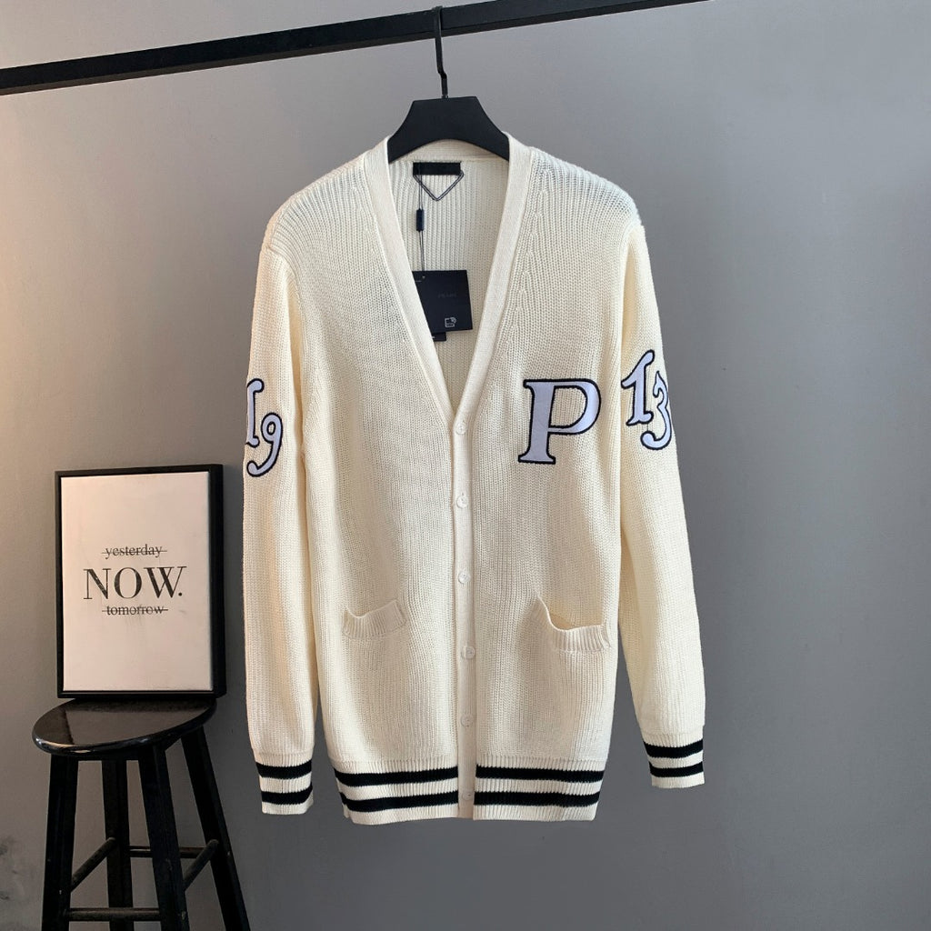 Ivory knit cardigan with navy graphic and black striped cuffs