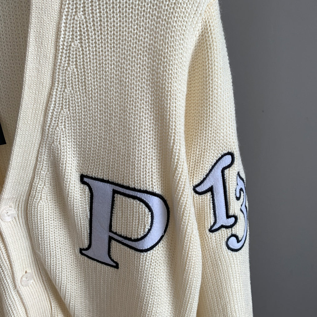 Ivory cardigan sleeve with large navy appliqué letter outlined in black