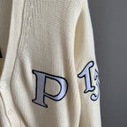 Ivory cardigan sleeve with large navy appliqué letter outlined in black