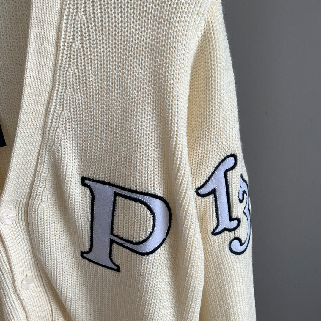 Ivory cardigan sleeve with large navy appliqué letter outlined in black