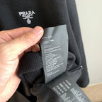Prada knit sweater fabric with attached size and care tags, dark gray