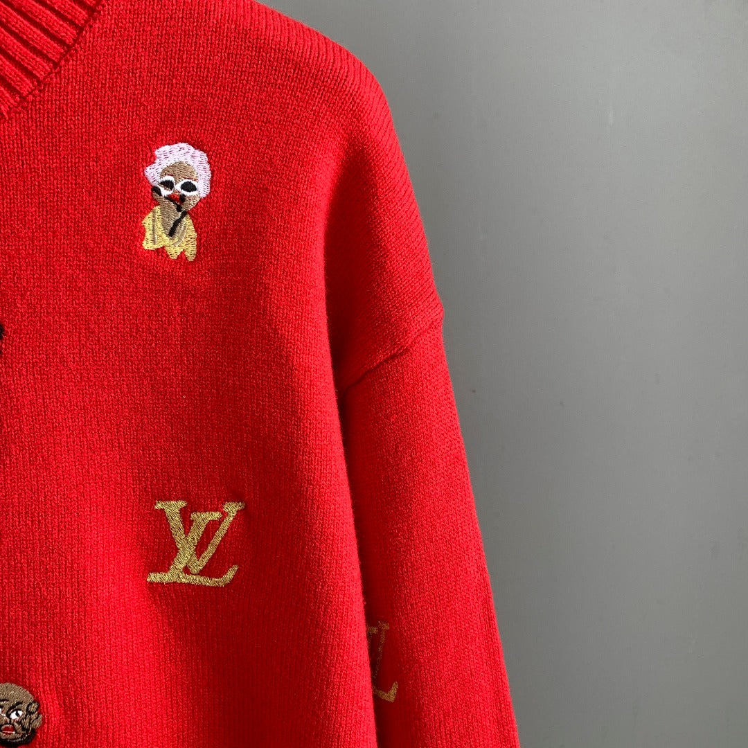 Red sweater detail with embroidered Louis Vuitton emblem and small doll face patch