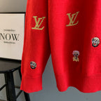 Red sweater lower sleeves with embroidered face patches and gold Louis Vuitton logos