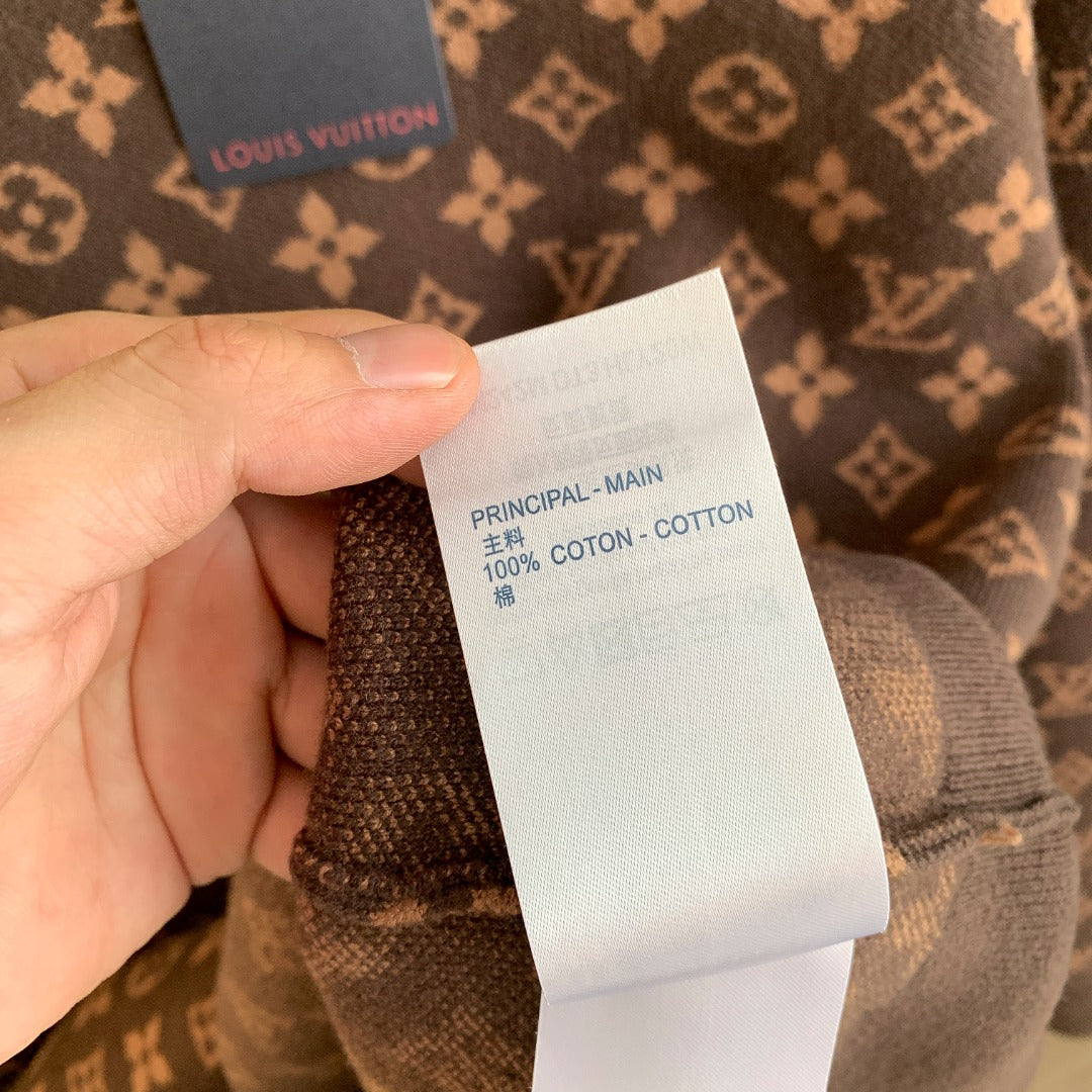 Fabric composition tag on knit sweater: 100% cotton, principal main