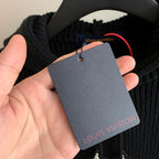 Hooded knit sweater with brand tag held in hand attached to the neckline