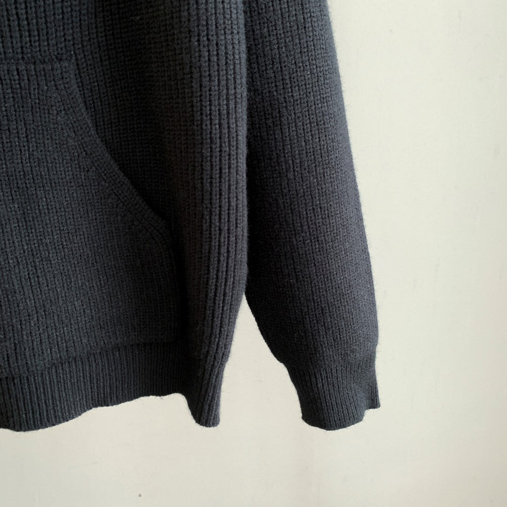 Dark hooded knit sweater sleeve and lower hem with ribbed cuffs and textured knit
