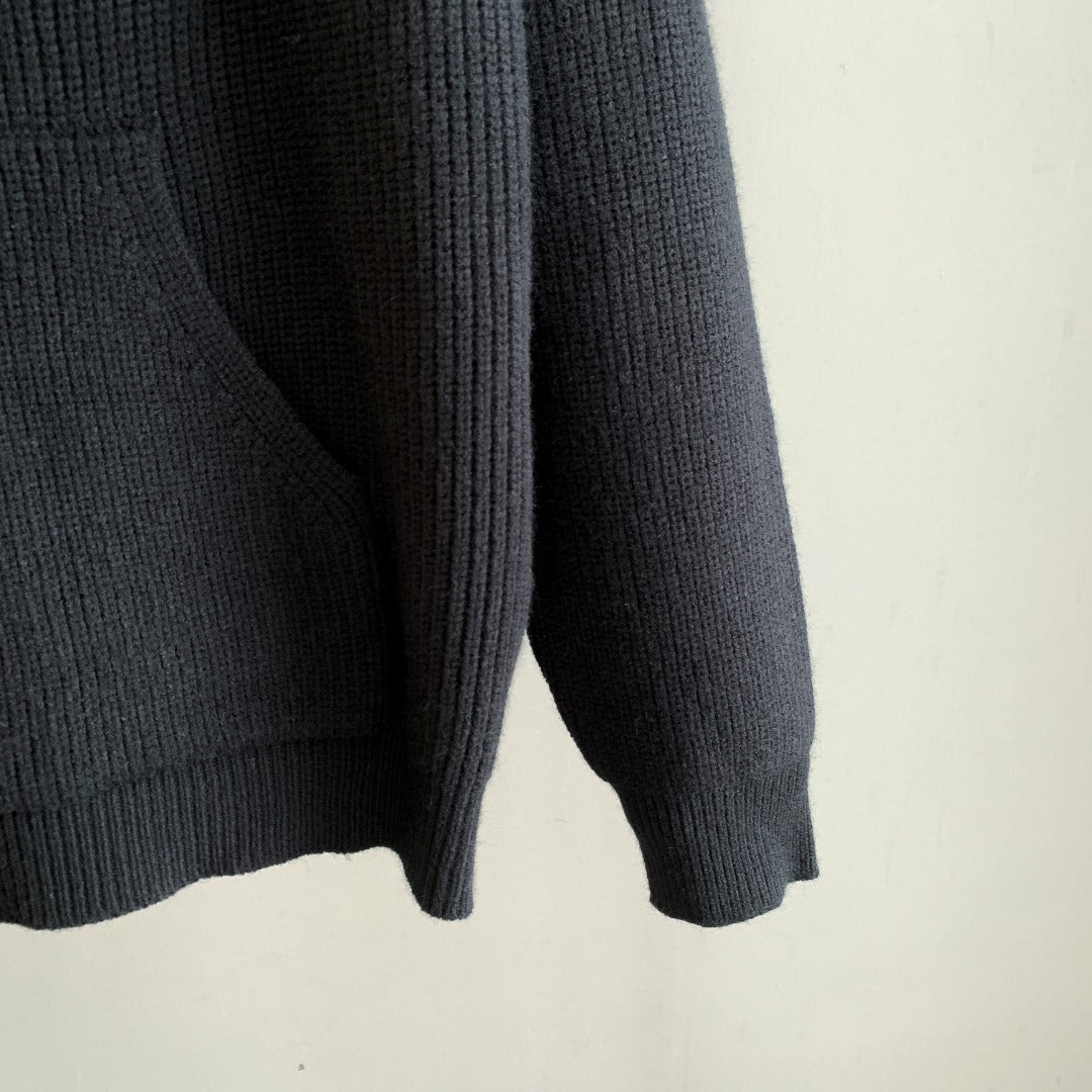 Dark hooded knit sweater sleeve and lower hem with ribbed cuffs and textured knit